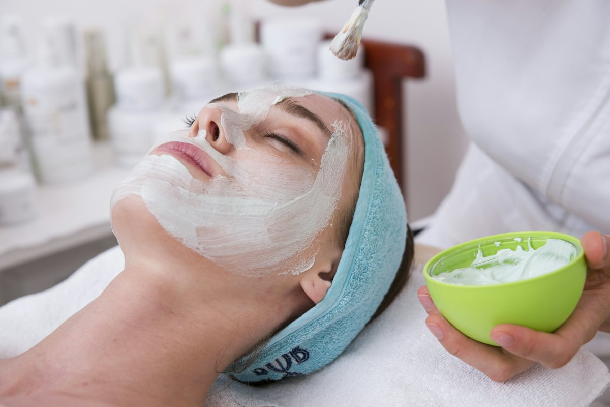 A guest relaxing during a facial with a cream mask