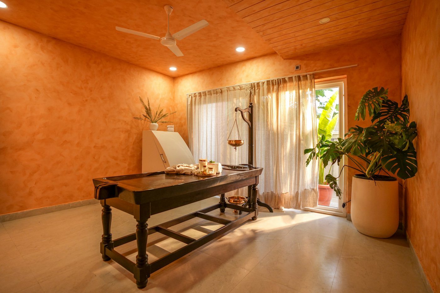 A warm, calm treatment room with a massage table